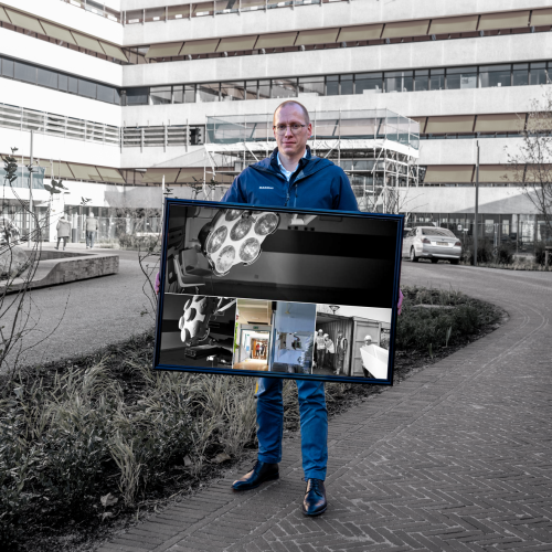Een man staat met een fotolijst in zijn handen. 